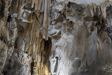 Inside view of cave with  a lot of vertical stalactites and stalagmites. Speleology destination