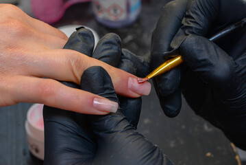 Close-up manicure process, female hands painting nails