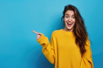 Image of happy young lady standing isolated over blue background. Looking camera pointing.