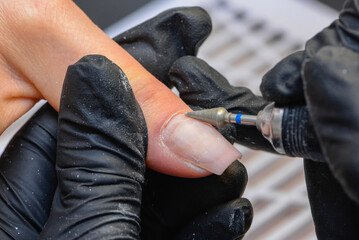 Close-up manicure process, female hands painting nails