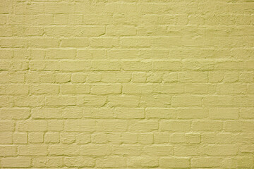 Fototapeta premium The brick wall is painted with yellow paint. Abstract construction background.