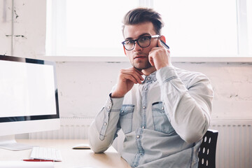 Confident male programmer talking with operator for checking account balance looking at camera...