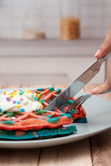 Desayuno close-up waffles de colores para desayunar en la cocina, cortando waffle