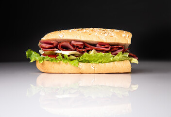 sandwich in a crispy loaf on a black background with reflection