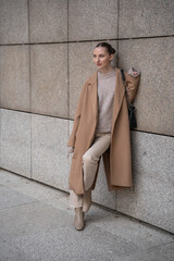 Young beautiful woman wearing coat walking in the city centre of Prague, Europe