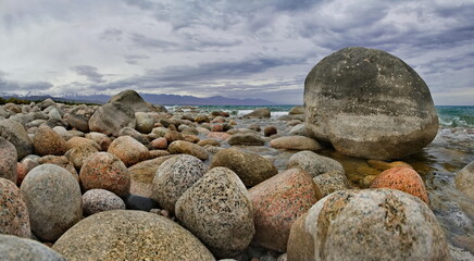 Northern Kyrgyzstan. The landscape of the cold Issyk-Kul lake with colored rounded stones of...