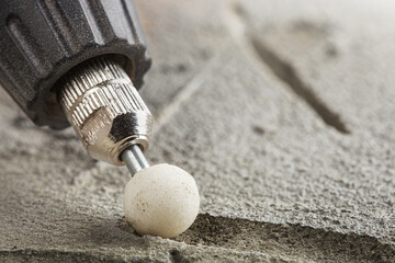 grinding bevel of ceramic tiles by grinding stone using drill.