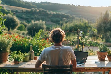 A man is sitting at a table with a laptop