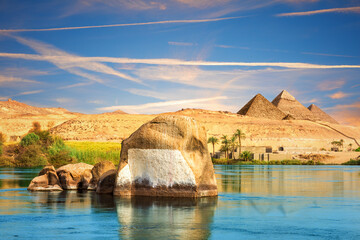 The Nile river and traditional ancient rocks on the way to pyramids, Aswan, Egypt