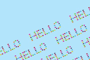 Creative idea made of candies on a blue background. Summer concept. Colorful candy pattern with copy space.