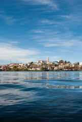 Beautiful view of the Río Negro reflecting the city of Viedma, Argentina. The blue sky and calm water highlight the natural and architectural beauty (2018)