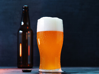 Craft beer India Pale Ale glass , dark background. An open beer bottle