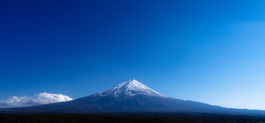 Fototapeta premium A cloudless sky stretching for miles, alongside the majestic Mount Fuji, a landmark of Japan.