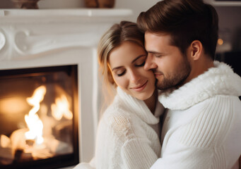 Relaxed beautiful man and woman, young loving couple in the house in front of cozy chimney fireplace with burning wood. Romantic evening with candles in a countryside. celebrating Valentine's day