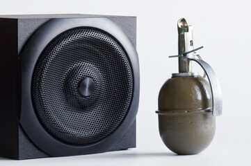 Hand grenade next to a black audio speaker - audio system. Create a visual metaphor for powerful...