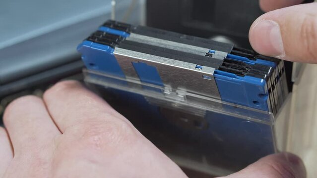 Man browsing vintage computer floppy disks in a storage box.