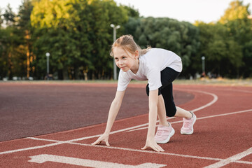 Pre-teen girl ready to race on an athletics track. Children sport, accomplishment , healthy active...