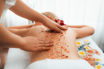 Closeup woman customer having exfoliation treatment in luxury spa salon with warmth candle light...