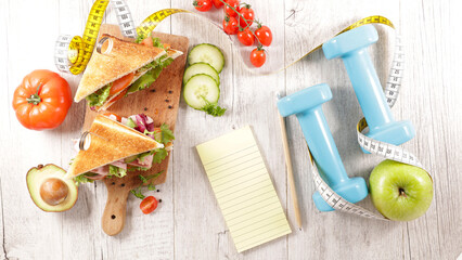 diet food concept- sandwich with note and dumbbell