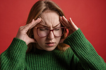 severe headache, brain spasm, portrait of a girl with glasses squeezing her hands to her temples