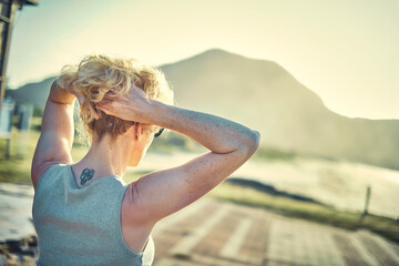 Back view of a young blonde woman with a tatoo in is nape outdoor.