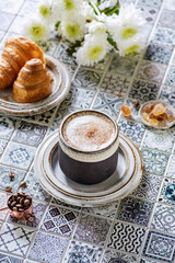 cappuccino with croissant on the table