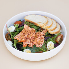Salmon and lettuce salad with cherry tomatoes and quail eggs angle view