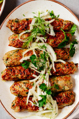 Chicken Lula Kebab with  onions on a platter.top veiw