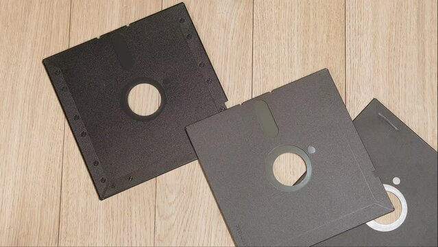 Throwing old vintage 5.25 inch floppy disks on a table.