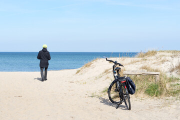 Fototapeta premium Sand dunes with beach grass at Baltic Sea near the town of Kuehlungsborn with a view of the blue sea and blue sky on a sunny day