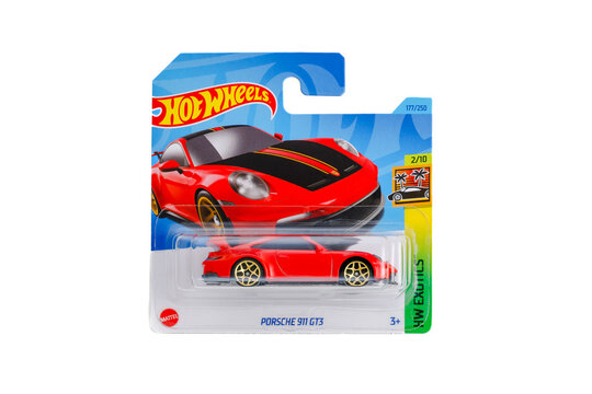 a die cast hot wheels toy unopened in packaging with plain white background. Red Porsche 992 911 GT&pound; with Weissach package. Carbon and gold wheels