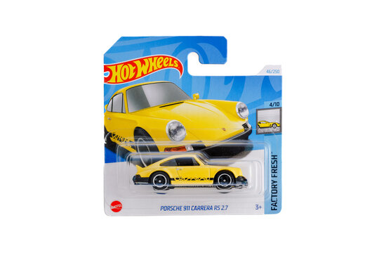 a die cast hot wheels toy unopened in packaging with plain white background. 1980s Porsche 911 Carrera RS 2.7. Yellow paint black bumpers