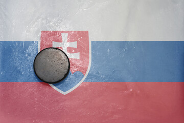 old hockey puck is on the ice with national flag of slovakia .