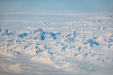 Snowcapped mountains in Greenland seen through an airplane window