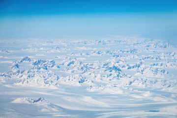 Snowcapped mountains in Greenland seen through an airplane window