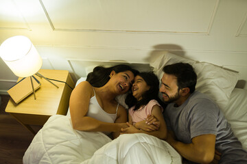 Family bonding in bed at night, enjoying a cozy and peaceful moment with soft lighting