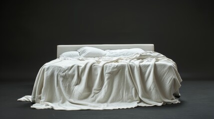 Close frontal shot of a contemporary bed draped in a white blanket, with a dark contrasting background, isolated on white