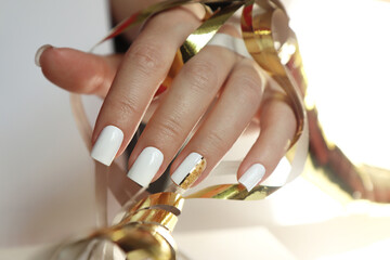 White manicure on short nails with a golden design.
