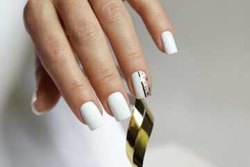 White manicure on short nails with a golden design.