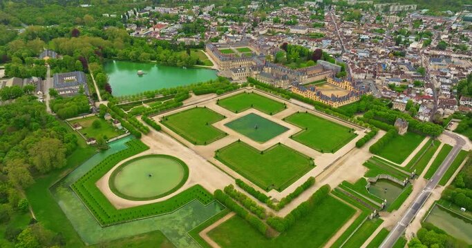 Aerial view of medieval landmark royal castle Fontainebleau and adjacent park area with lake, France