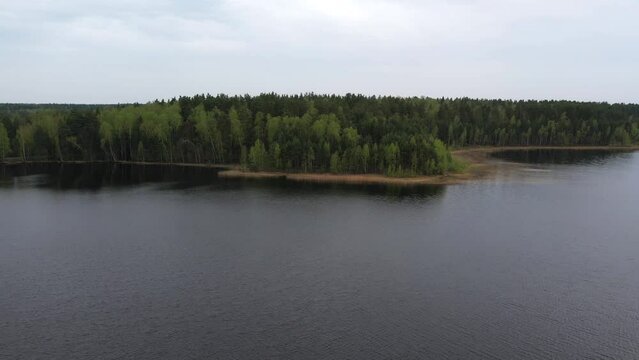 Bird's eye view of the lake in the forest. It's cloudy outside. Hiking trip