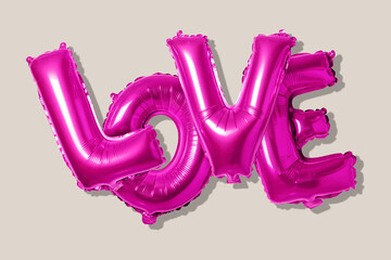 Word love in english alphabet from pink balloons on a bright background. Minimal love concept.