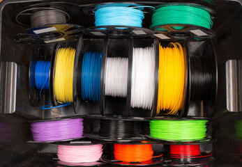 black box  filled with colorful  3d printing filament spool like PLA PETG ABS. Modern technology and material DIY background