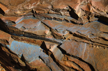 Blue patterns and structures on layers of banded ironstone formations in Karijini National park, in the Hamersley Range, Western Australia
