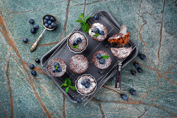 Traditional American oatmeal muffin with blueberries and walnuts served as top view a baking tray