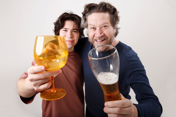 father and teenage son toasting with beer