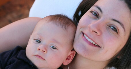 Happy mother and baby infant portrait faces looking to camera