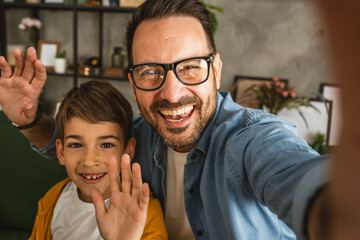Father and son make a self portrait at living room