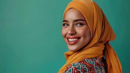 A positive Muslim woman smiles happily while wearing a traditional yellow headscarf, looking directly at the camera