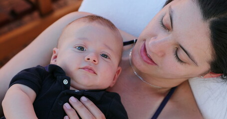 Mom and infant baby son together outside looking to camera